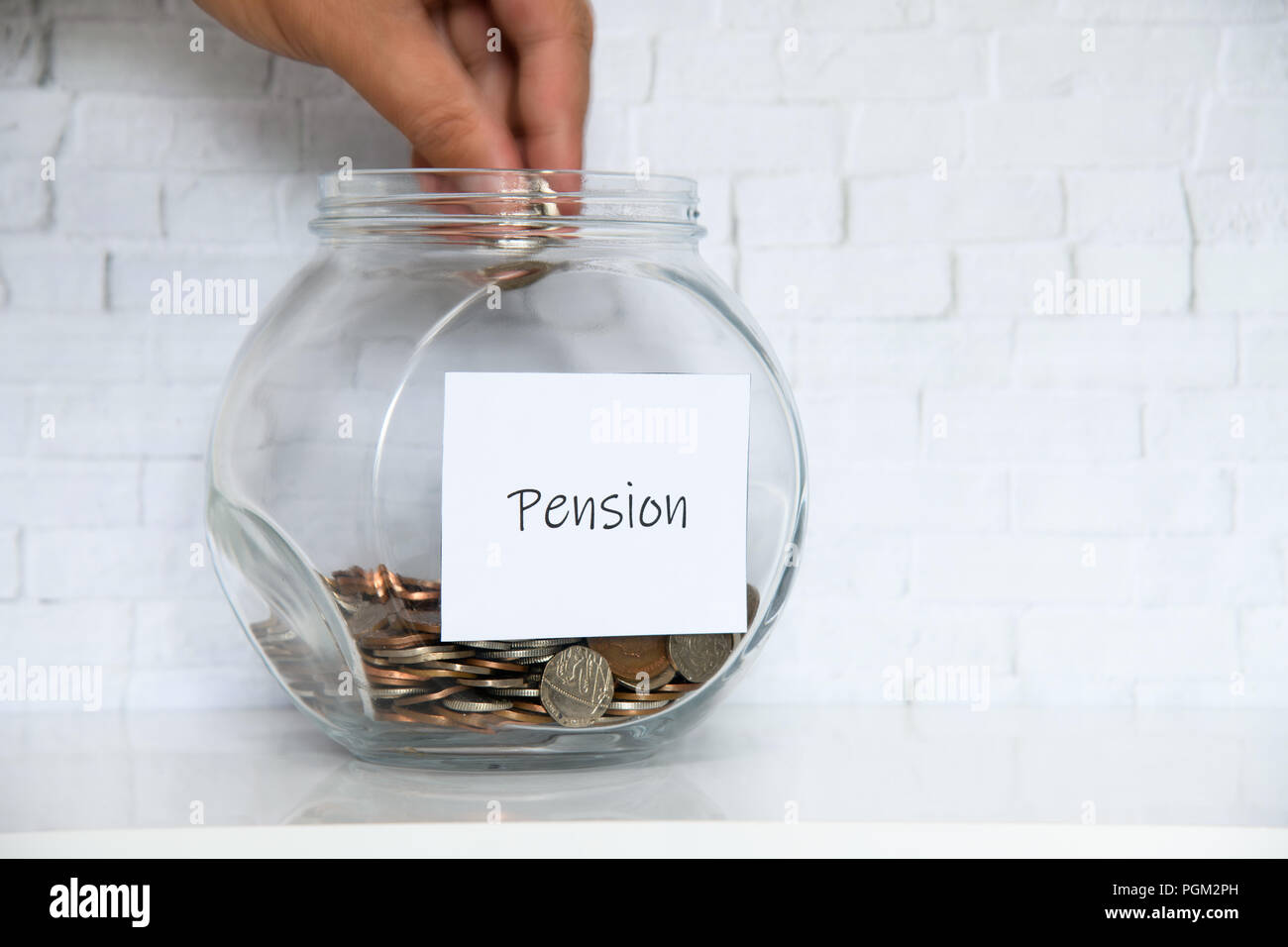 Regno Unito giara di denaro su un ripiano bianco in una famiglia in soggiorno. Il risparmio per il concetto di pensione Foto Stock