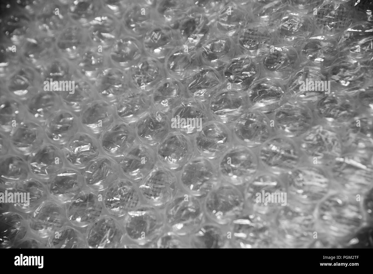 Bubble wrap tessitura usata per il confezionamento di articoli fragili su sfondo grigio Foto Stock