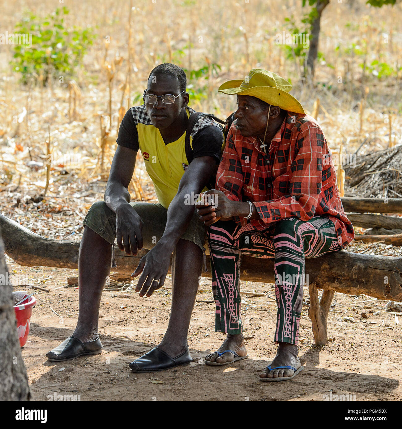 KOUTAMMAKOU, TOGO - Jan 13, 2017: Non identificato gli uomini Togolese sedersi sul montante in legno nel villaggio. Il Togo di persone soffrono di povertà a causa della cattiva eco Foto Stock