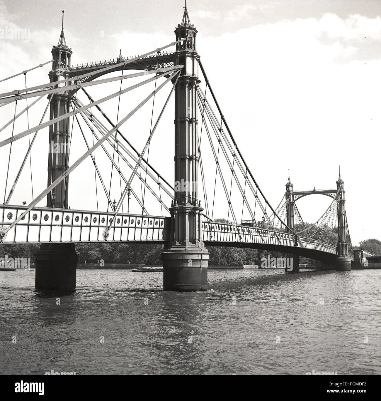 Degli anni Cinquanta, storico, una vista dal ad ovest di Hammersmith Bridge London, guardando attraverso il sud e Barnes. Il primo ponte sospeso sul fiume Tamigi, West London, England, Regno Unito, il ponte si vede qui è la seconda - Sostituzione - uno, costruito nel 1887, che poggia sullo stesso molo fondazioni.come prima. Foto Stock