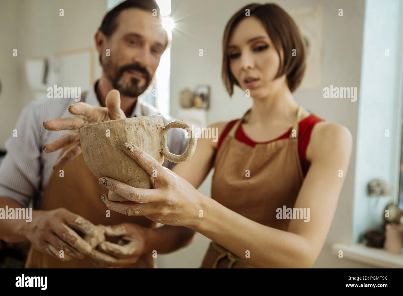 Dai capelli scuri ceramisti professionisti azienda grande tazza da tè Foto Stock