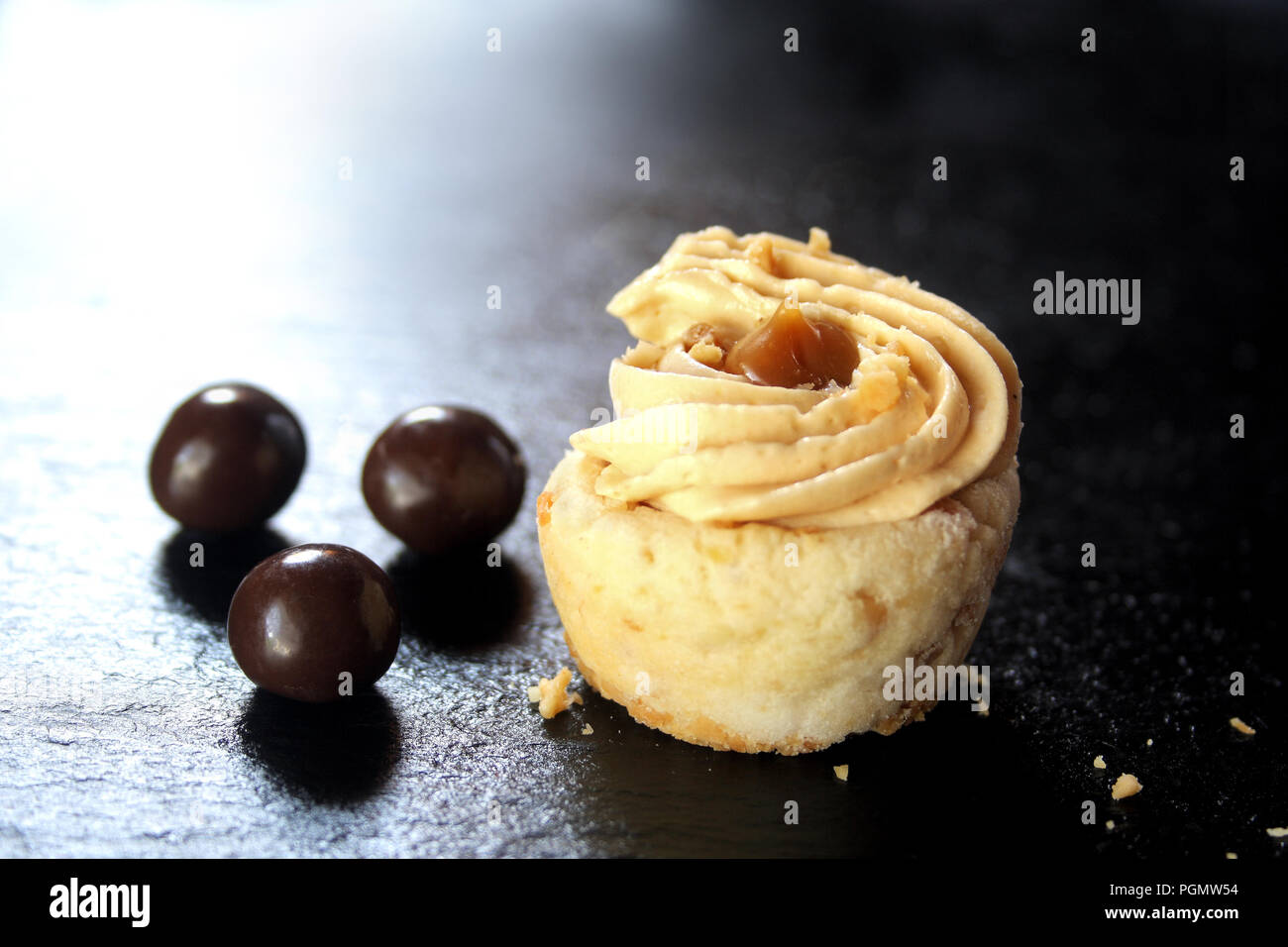 Mini crostata al caramello nero su sfondo di pietra Foto Stock