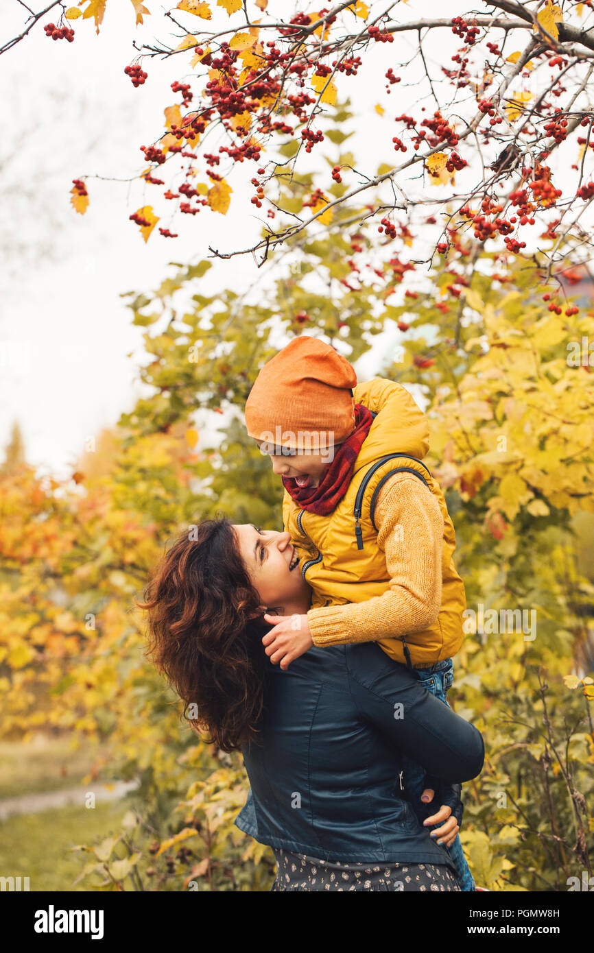 Madre e figlio insieme. La famiglia felice costeggiata in autunno parcheggiare all'esterno Foto Stock