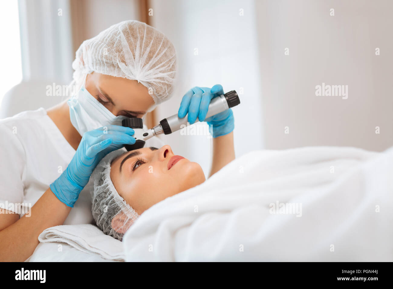 Smart medico professionale cercando la dermatoscope Foto Stock