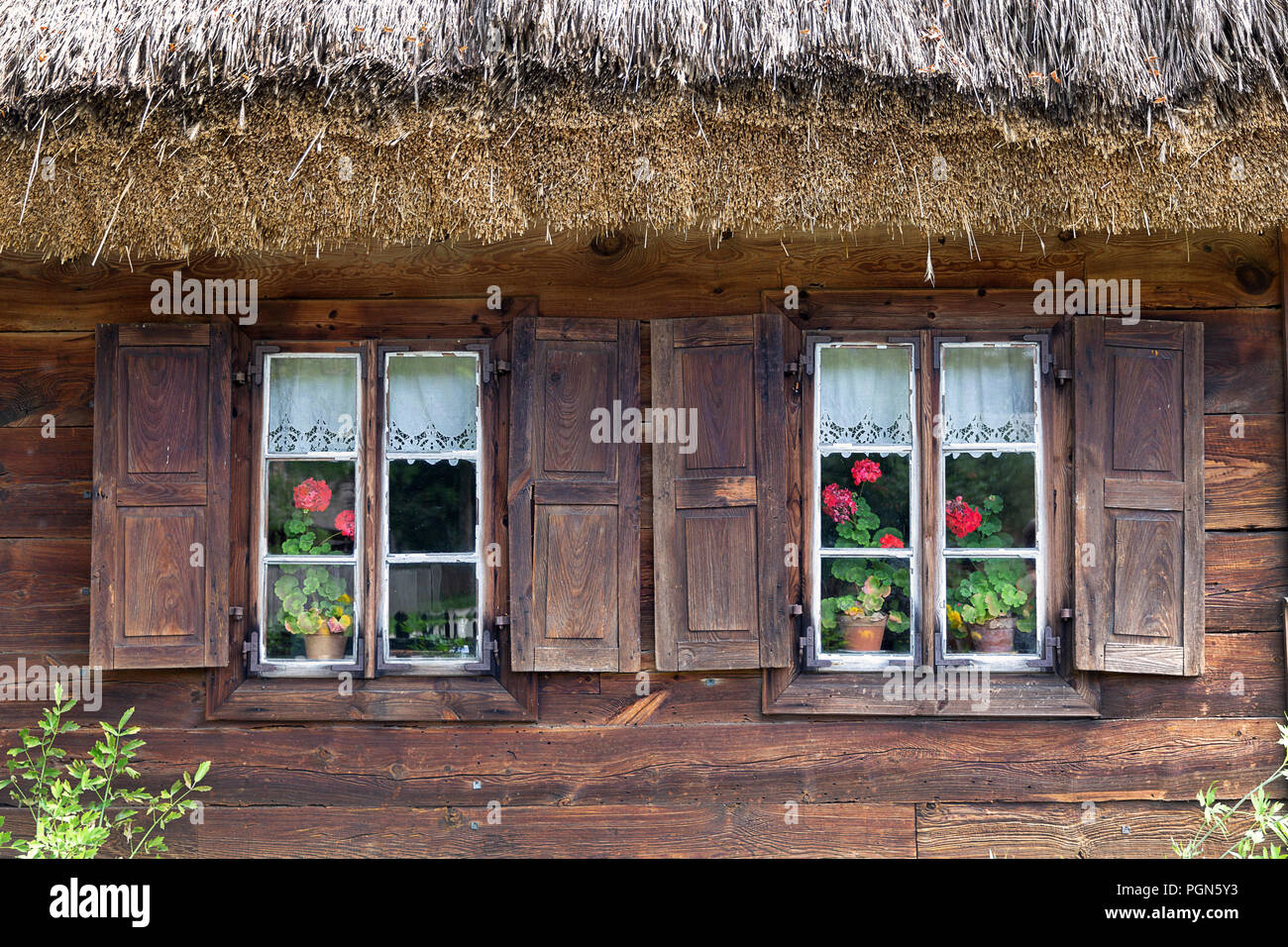 Vecchia casa in legno con persiane alle finestre Foto Stock