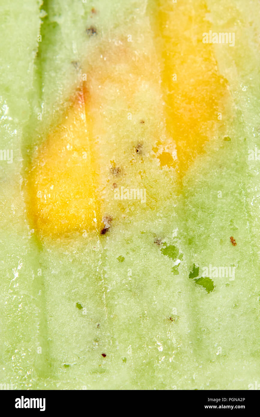 Foto macro di congelati Succhi di frutta con una fetta di mango. Sfondo di cibo Foto Stock