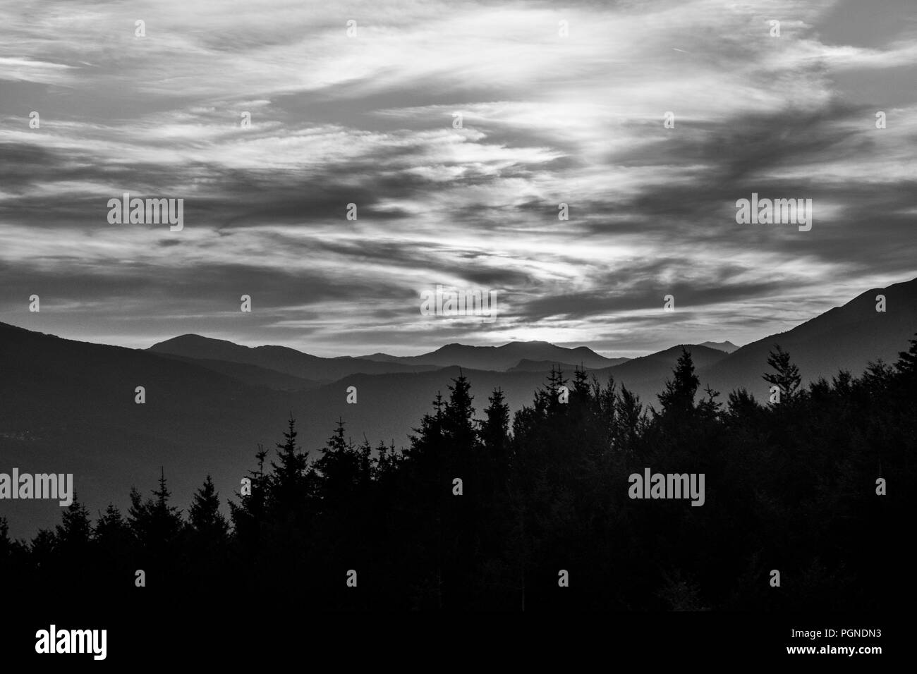 Profilo di montagna e foresta con cielo molto nuvoloso in bianco e nero Foto Stock