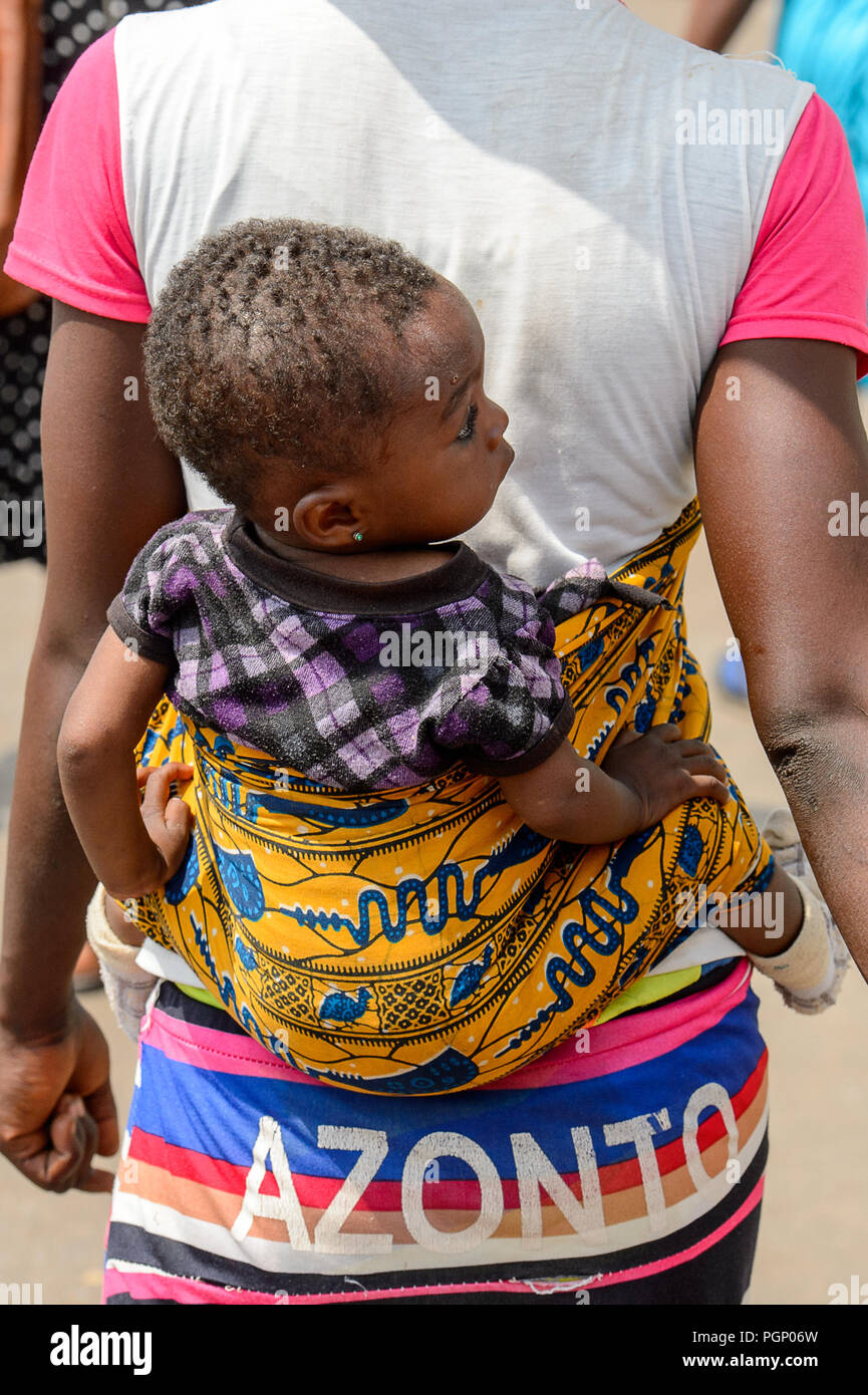 KUMASI, GHANA - Jan 15, 2017: Unidentified ghanesi bambina è portato da sua madre al mercato di Kumasi. Ghana i bambini soffrono di povertà a causa di Foto Stock