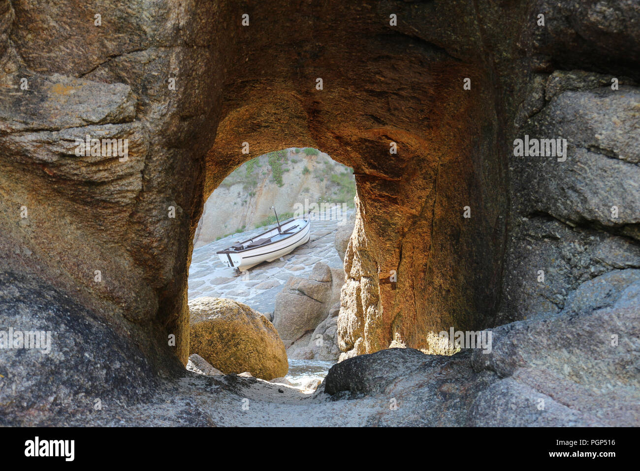 Barca da pesca su una slitta di lancio, visto attraverso un tunnel tagliato nella roccia, in Cornwall, Regno Unito, dove la pesca rimane una parte importante dell'economia Foto Stock