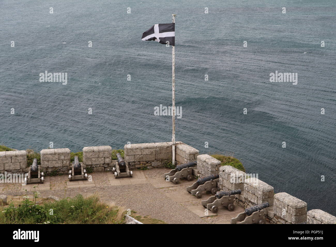 Giugno 2015 - Bandiera della Cornovaglia e vecchi cannoni sul tetto di San Michele è il Monte Castello in Cornovaglia, UK, che fu la residenza della stessa famiglia da app Foto Stock