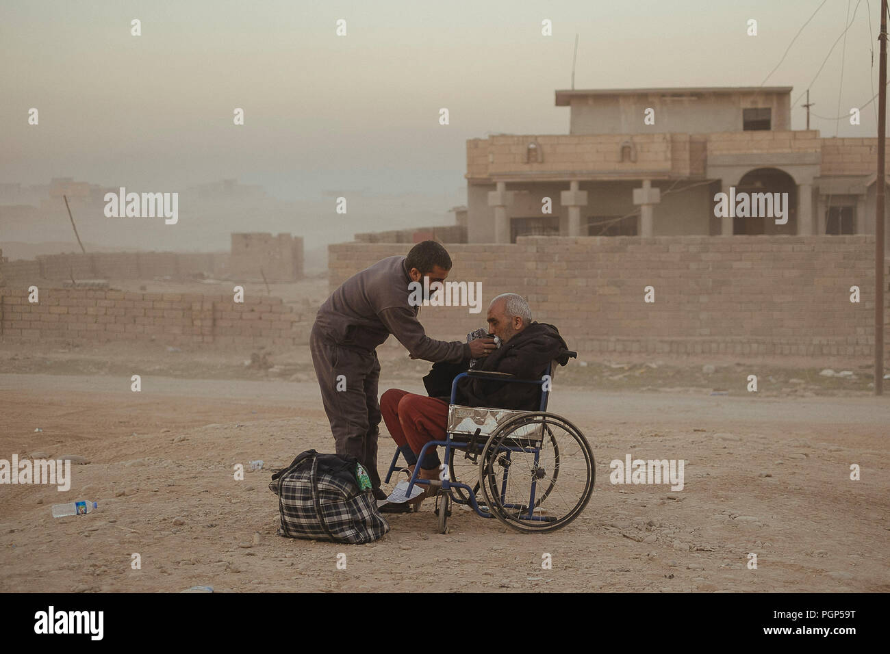 L ospedale di Gagjali, un sobborgo di Mosul, durante l offensiva contro ISIS. Un uomo e suo padre sulla sedia a rotelle al di fuori dell'ospedale. Gajali (IQ Foto Stock