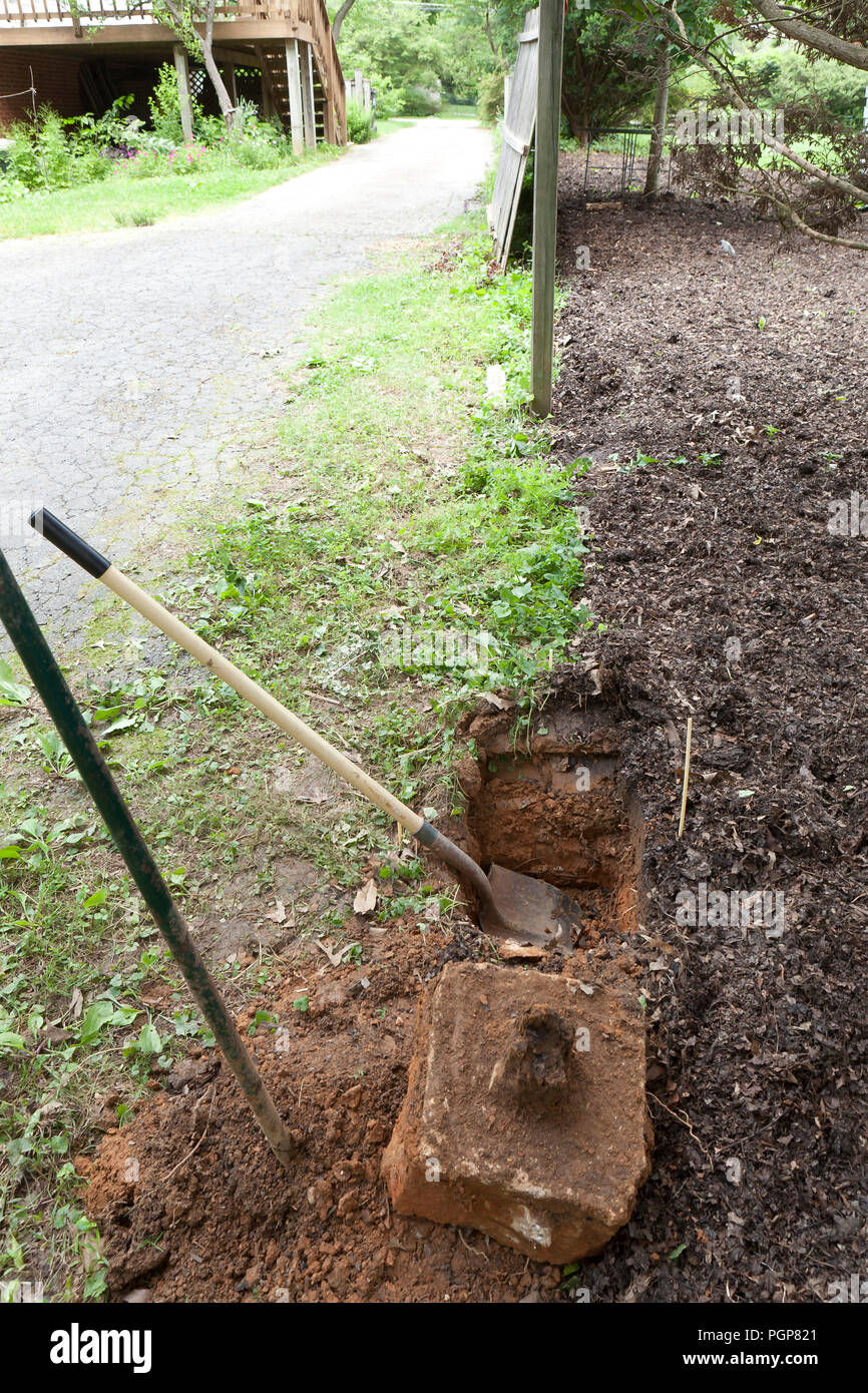 Palo da recinzione di fori nel terreno durante le riparazioni di recinzione - USA Foto Stock