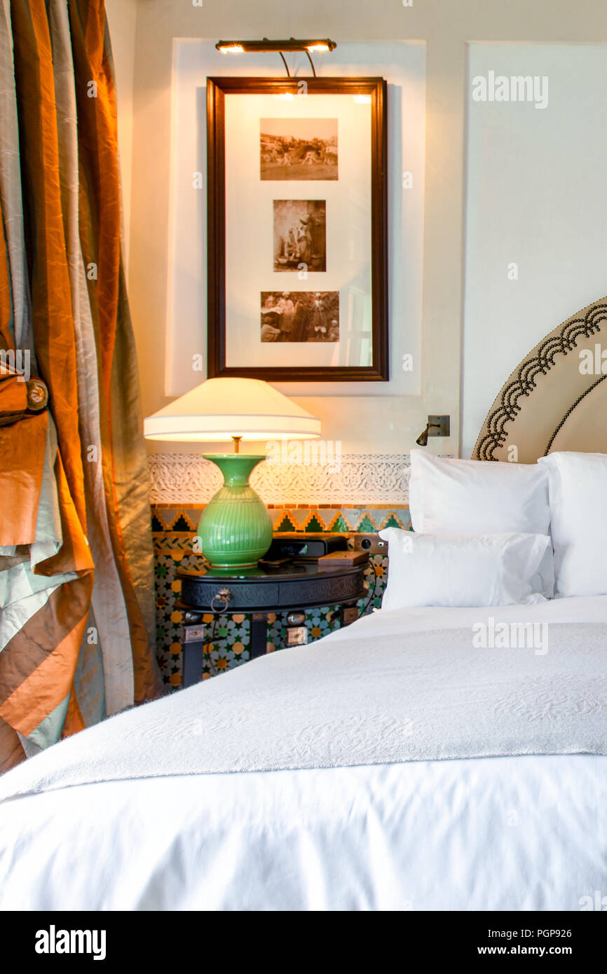 La camera da letto di lusso stile marocchino con biancheria bianca e finestra di seta di trattamento. Piastrelle in mosaico gli accenti. Camera elegante decor. Foto Stock