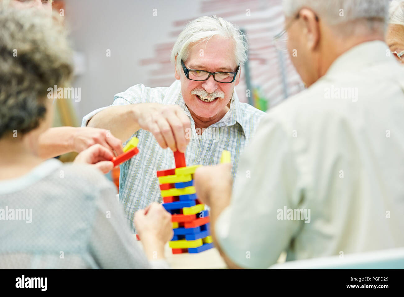 Gruppo di demenza in casa di riposo suona insieme a blocchi di costruzione come terapia Foto Stock