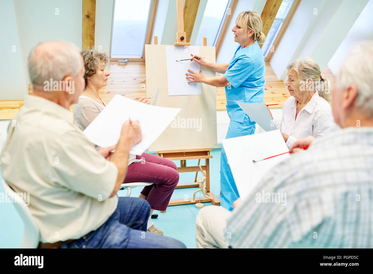 Gli anziani con demenza nel corso di disegno supervisionato da un terapeuta nella casa di cura Foto Stock