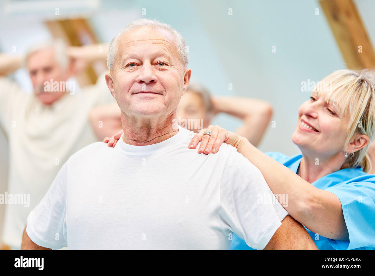 Terapista supporta senior uomo nella schiena sana formazione Foto Stock