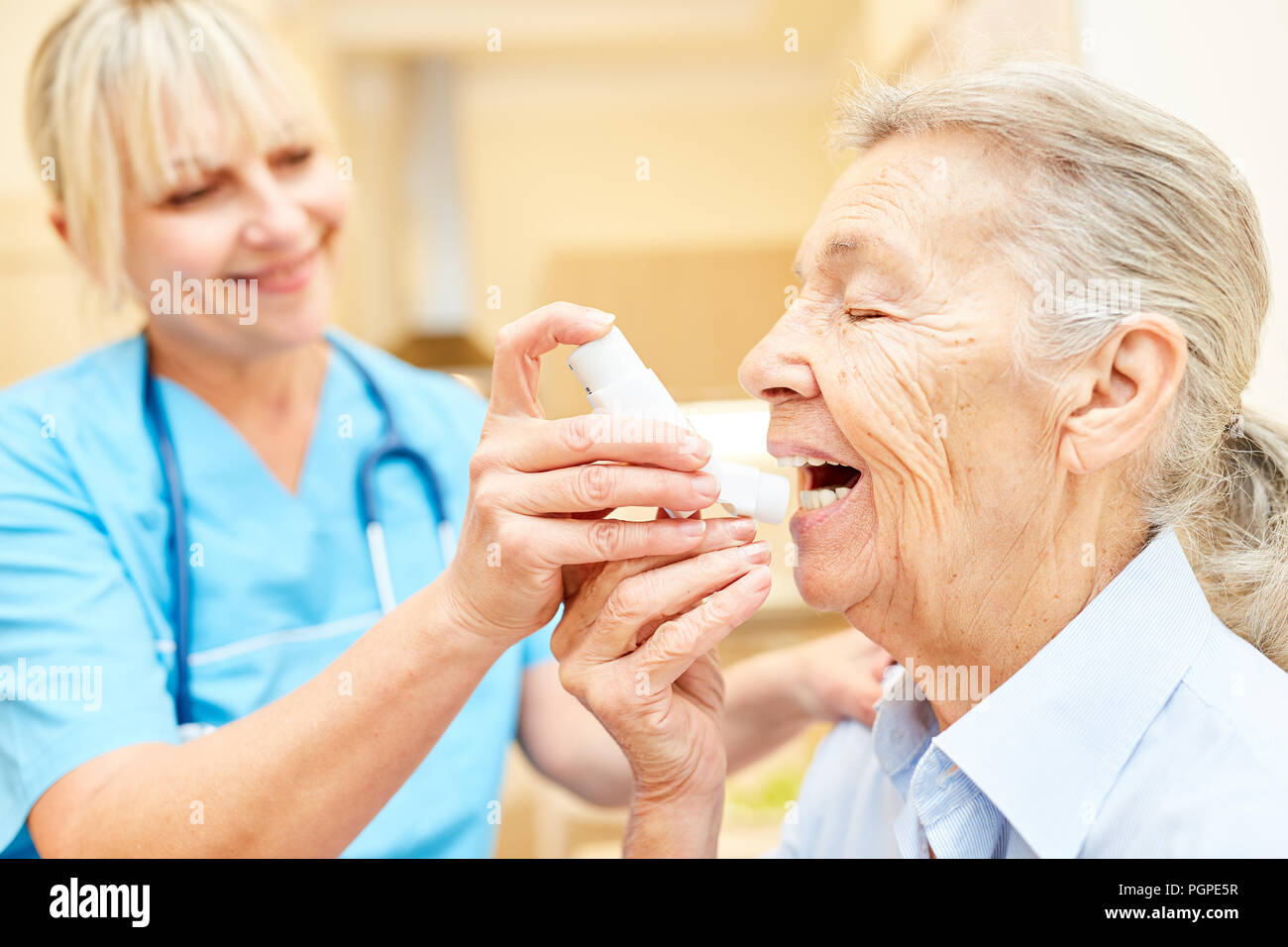 Senior nurse riceve aiuti di emergenza dal respiratore in sofferenza respiratoria con inalatore spray Foto Stock