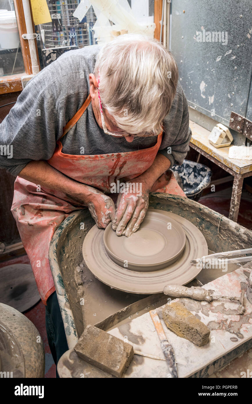 Il vecchio uomo di filatura ruota vasai rendendo la piastra di argilla,pilling,lancashire,l'Inghilterra,uk Foto Stock