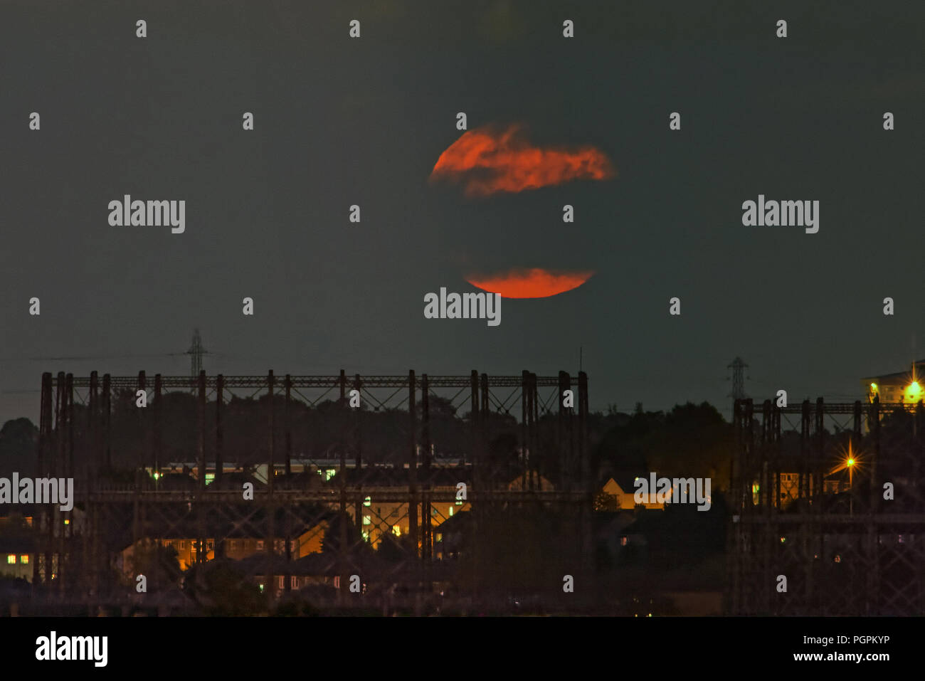 Glasgow, Scotland, Regno Unito. 27 Agosto, 2018. Regno Unito Meteo: Agosto la luna di storione su Glasgow va in rosso tra il cielo nuvoloso con i gasometri Kelvindale nel west end della città. Questo mesi luna purtroppo non è stato chiamato dopo Nicola ma dopo l'America del Nord la più grande pesce lo storione. Gerard Ferry/Alamy news Credito: gerard ferry/Alamy Live News Credito: gerard ferry/Alamy Live News Foto Stock