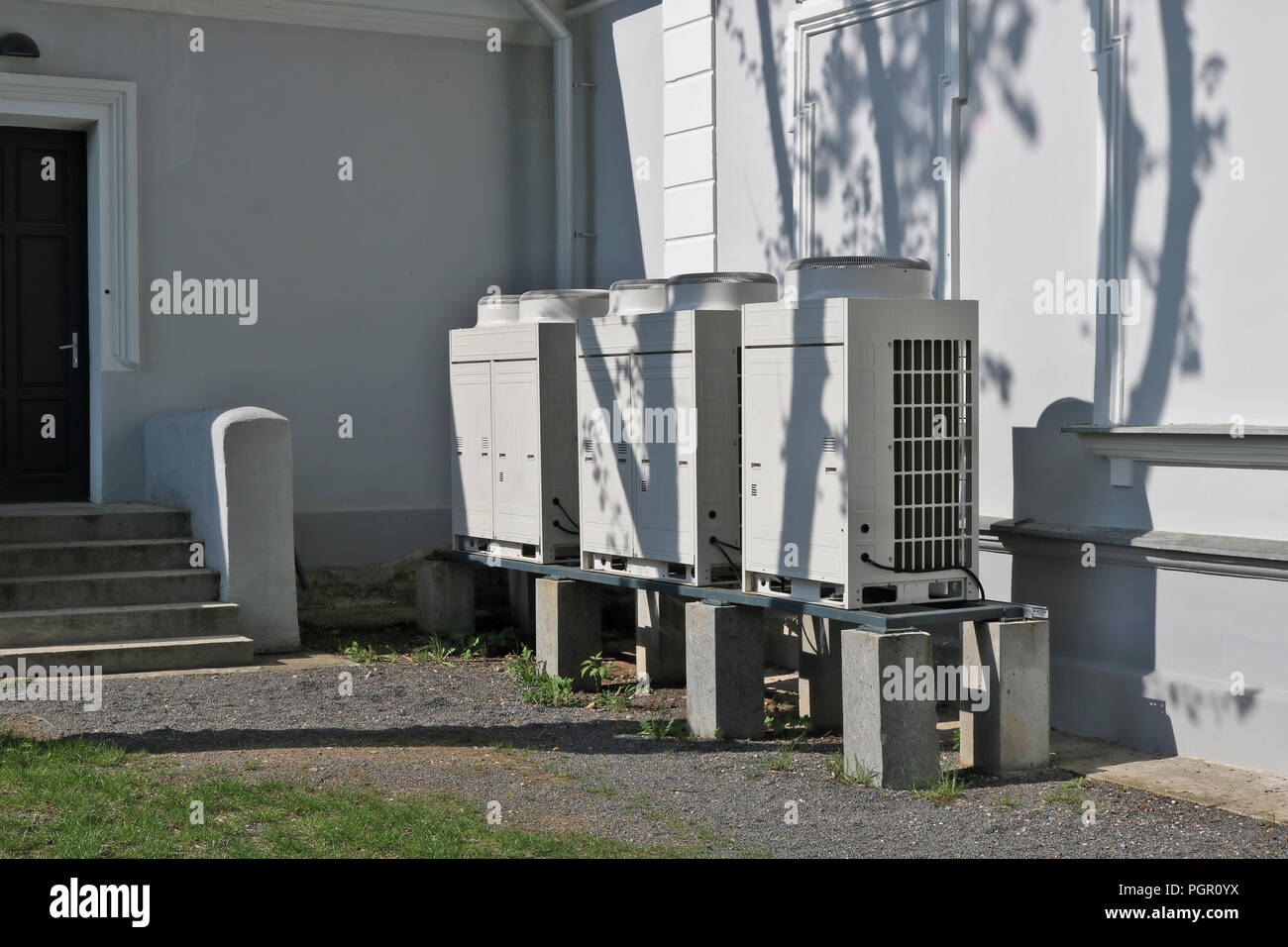 Tre moderni di alta potenza condizionatori d'aria a fornire un microclima ideale in un edificio per uffici. Soleggiata giornata di primavera urban shot Foto Stock