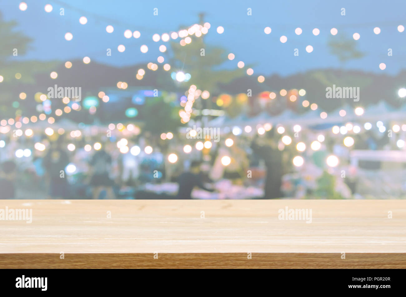 Parte superiore in legno tavolo astratto e sfocata mercato notturno. Può essere utilizzato per visualizzare o montaggio dei vostri prodotti. Foto Stock