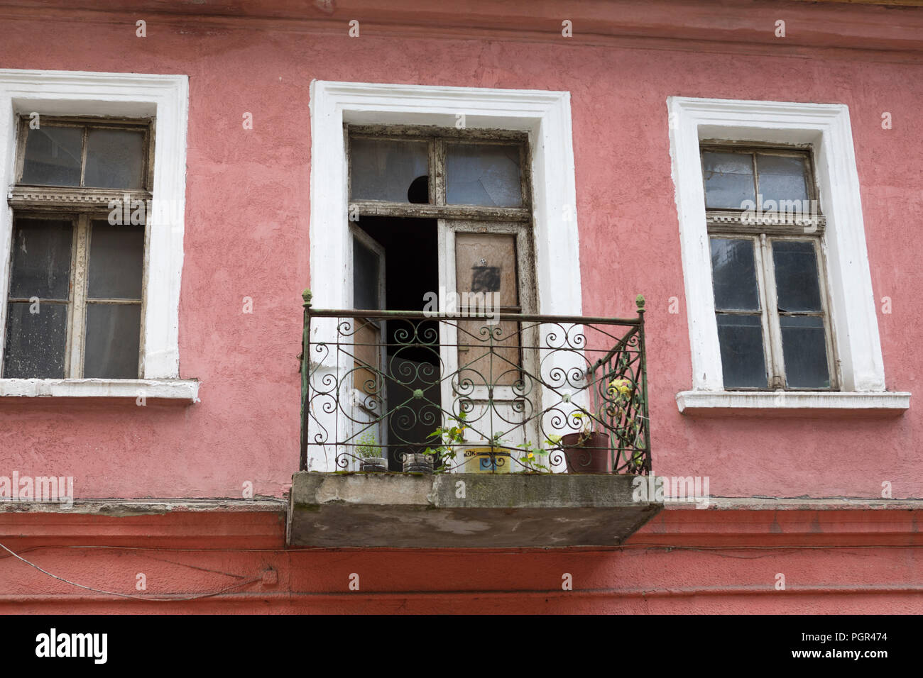 Facciata di un vecchio dipinto di rosa casa con balcone in ferro in Sofia Bulgaria Foto Stock