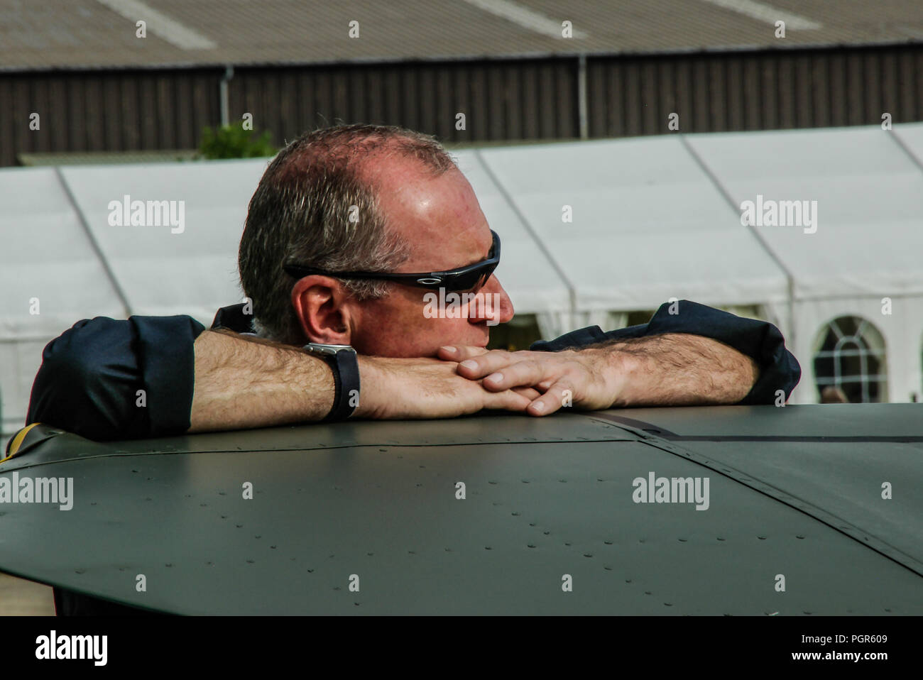Gruppo capitano Russ Allchorne, pilota con la Royal Air Force Battle of Britain Memorial Flight appoggiato su di un piano di Spitfire ala. RAF BBMF flyer Foto Stock