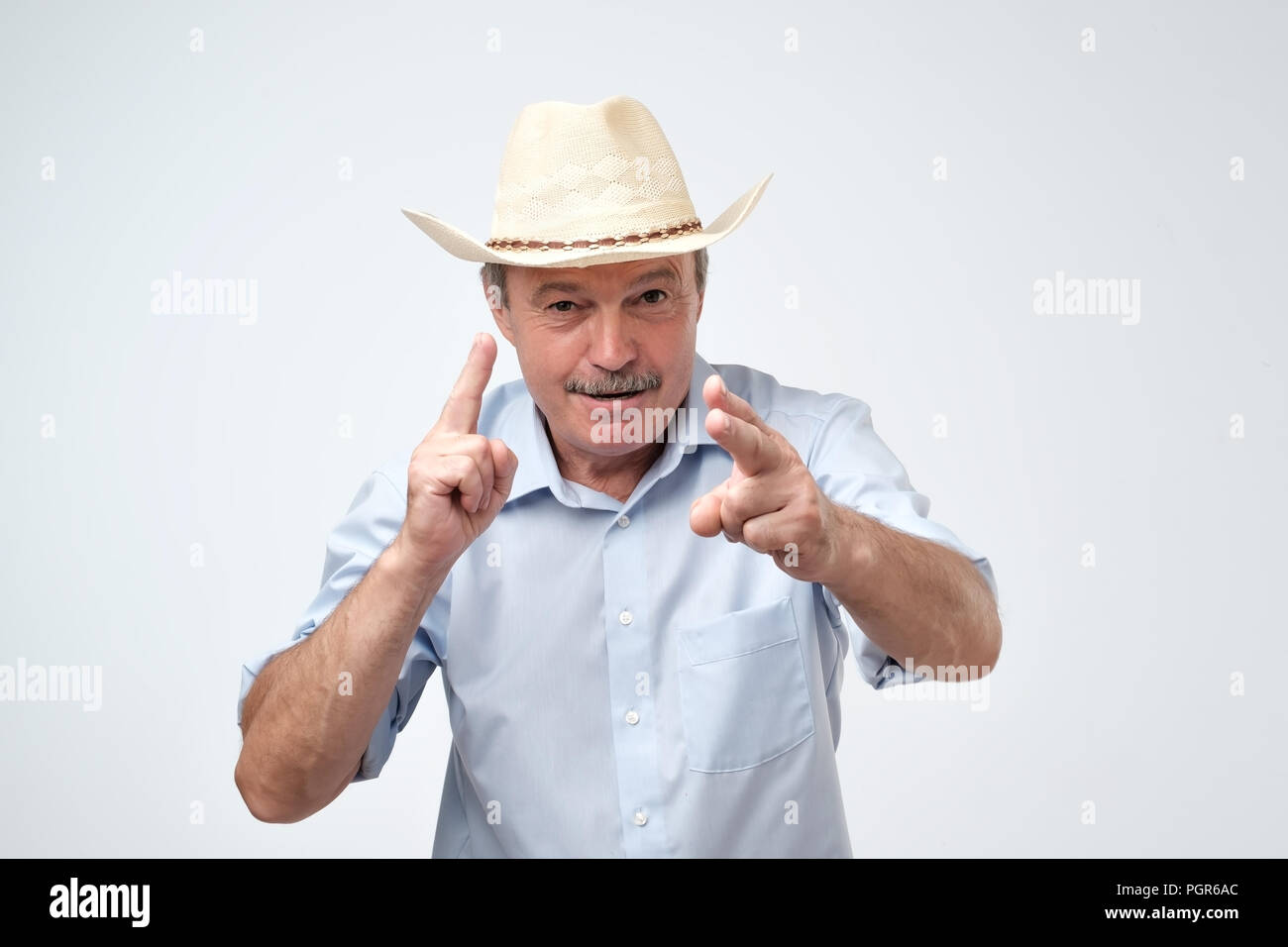 Coppia uomo caucasico nel cappello da cowboy facendo un segno con le dita come egli è ripresa in anticipo. Foto Stock