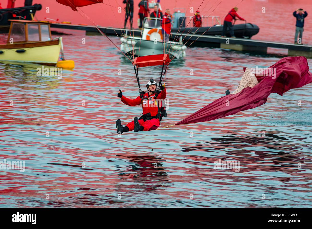 24/08/2018, Fowey, Cornwall, Regno Unito. Parachute team diplay i diavoli rossi effettuare un livello basso salto nel Fowey estuario del fiume a Fowey Royal Regata Foto Stock