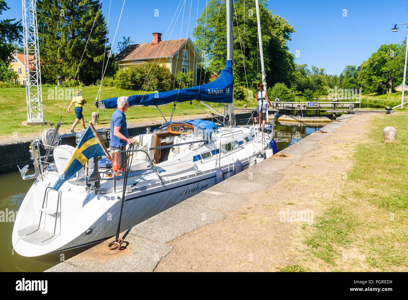 Tatorp, Svezia - Luglio 3, 2018: barca a vela in attesa per la saracinesca per essere aperto. Persone in piedi sulla barca i cordini e le paratie di protezione è walki Foto Stock