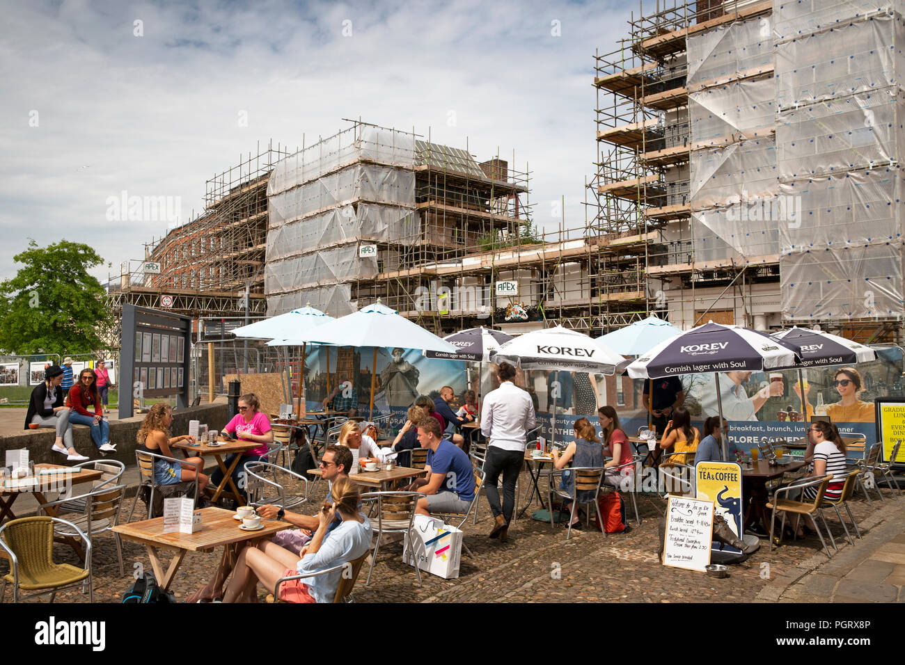 Regno Unito, Inghilterra, Devon, Exeter Cathedral Yard, pavement cafe tabelle nella parte anteriore del fuoco danneggiato Royal Clarence Hotel Foto Stock