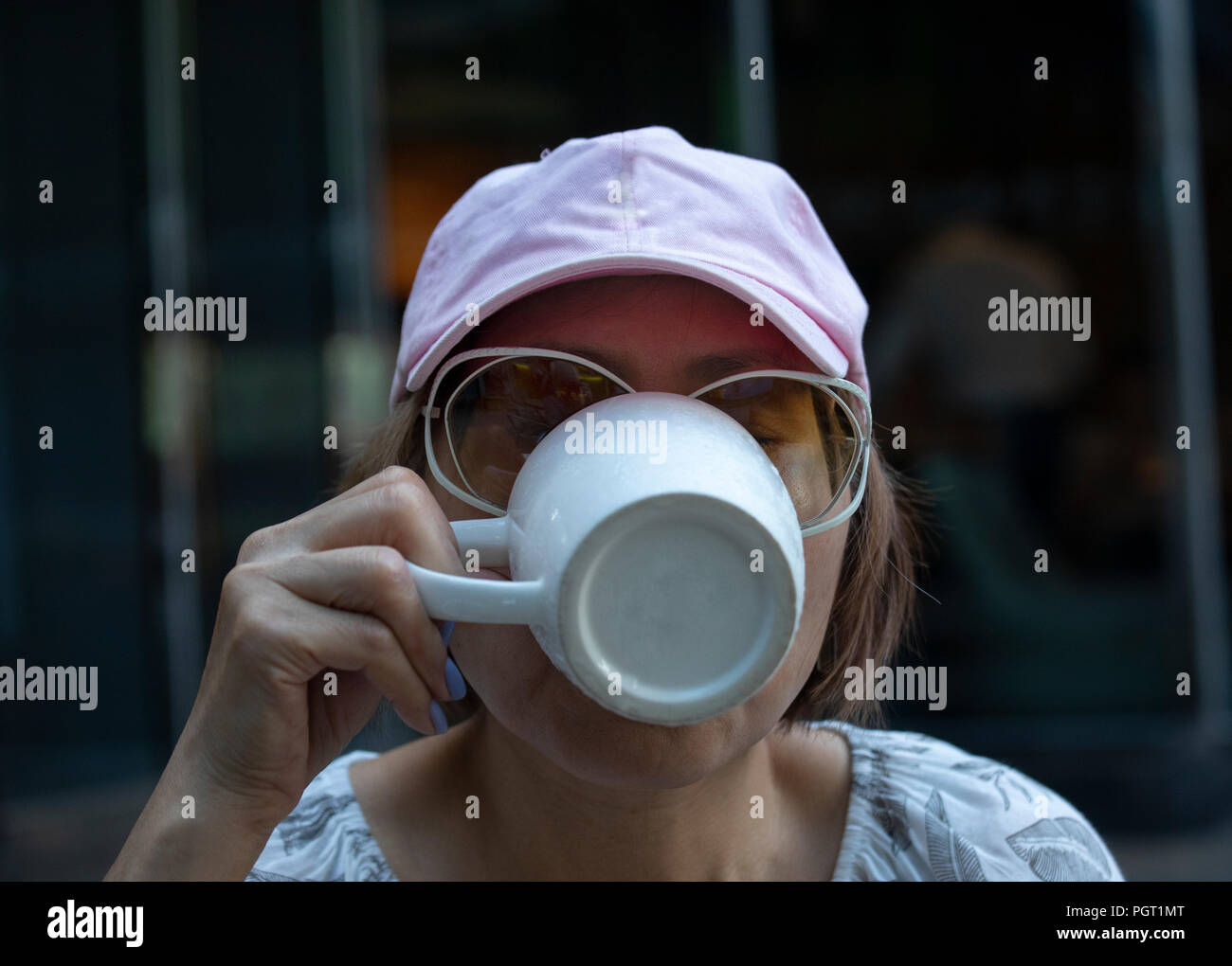 Ritratto di sete Taiwanese matura donna cinese di bere il caffè in una caffetteria Foto Stock