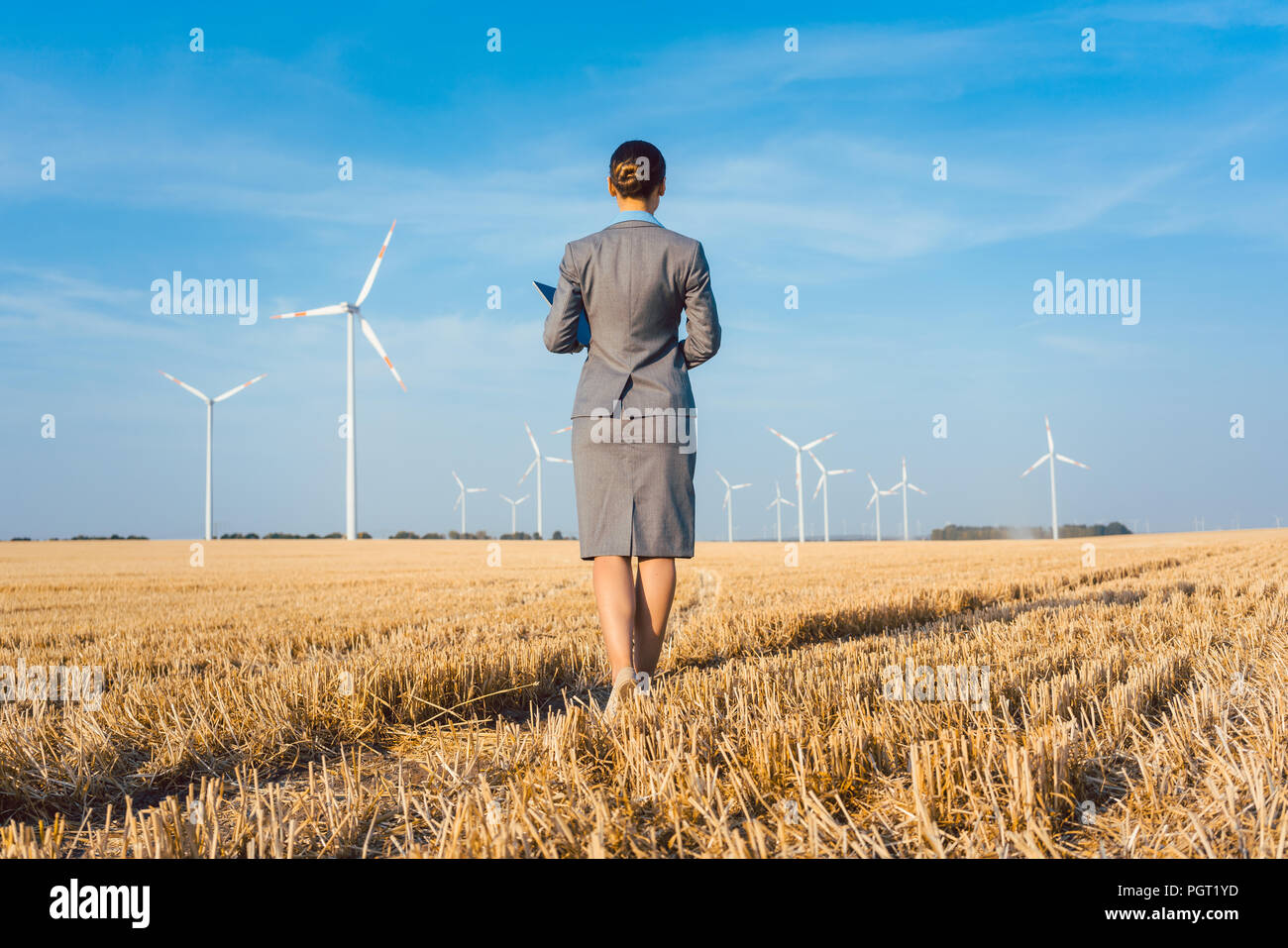Un investitore in energia verde guardando il suo turbine eoliche Foto Stock