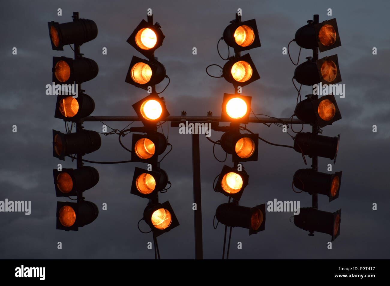 Riflettori su evento musicale con il grigio scuro cielo di notte, rosso proiettori Luci flash sullo sfondo Foto Stock