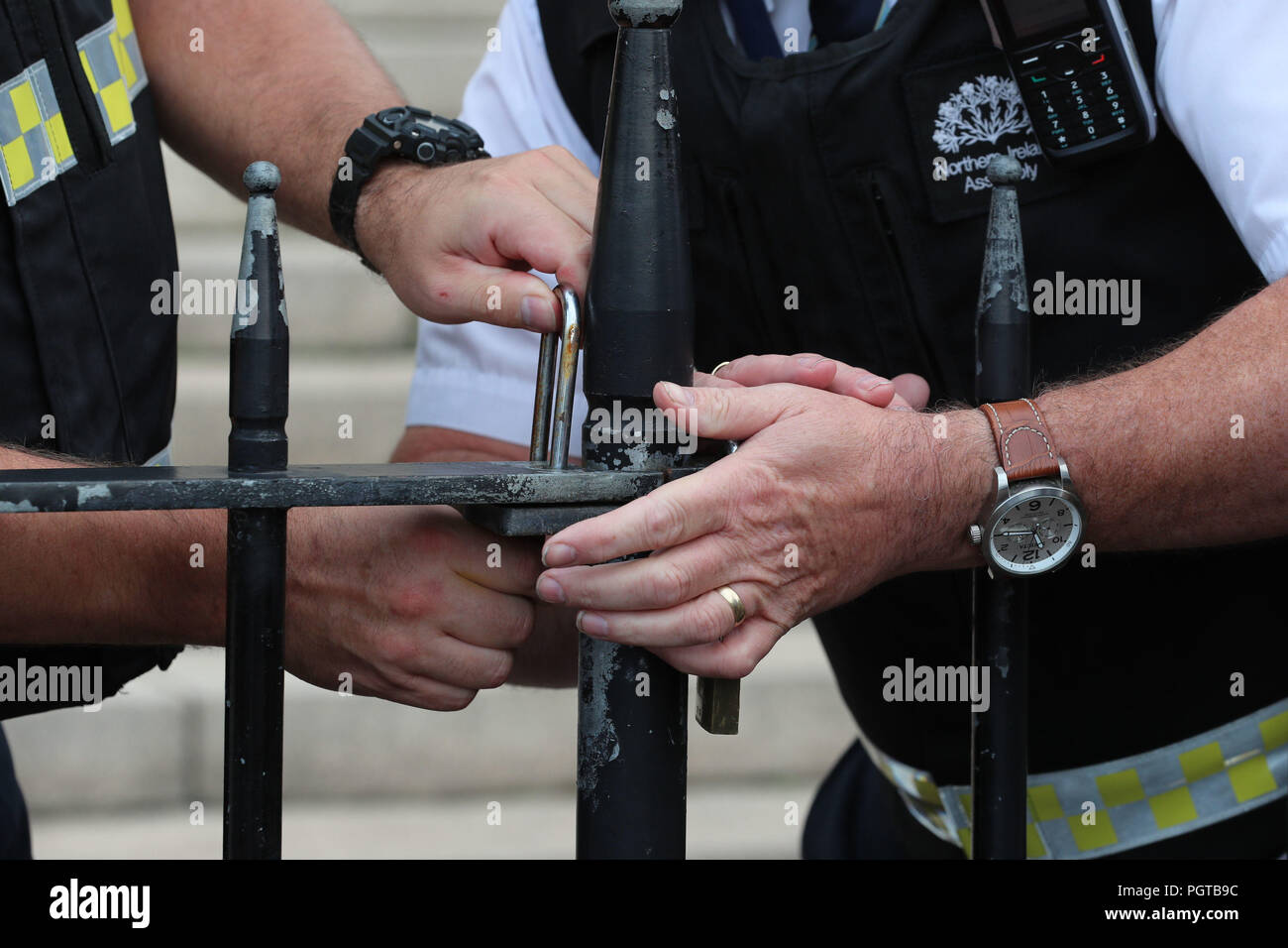 Una guardia di sicurezza blocca le porte fuori gli edifici del Parlamento di Stormont a Belfast. Il governo ha riconosciuto la profonda frustrazione del pubblico in Irlanda del Nord come la regione ha raggiunto una pietra miliare indesiderati per non-governance. Foto Stock