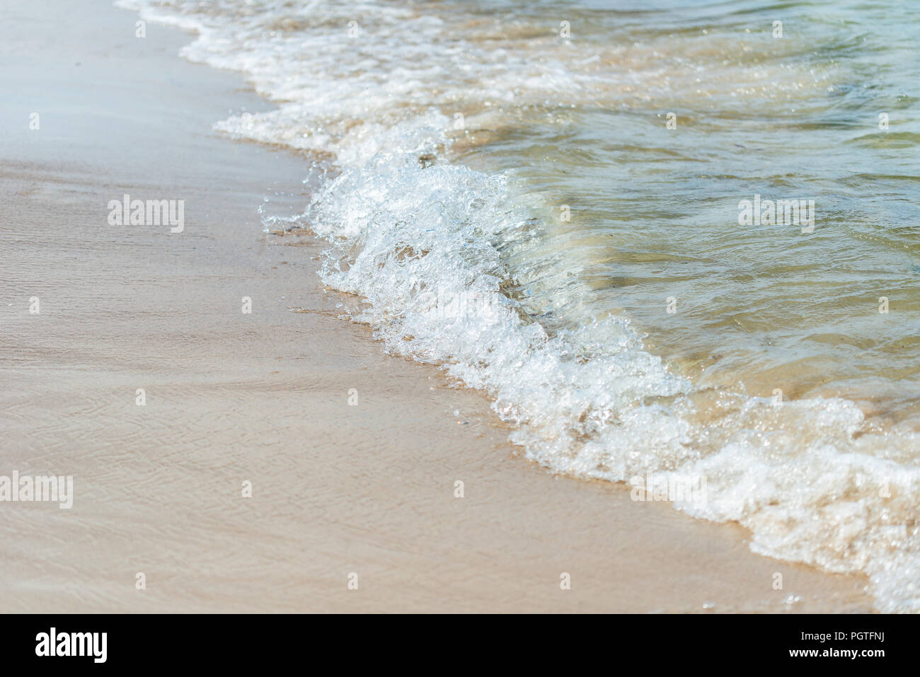 Onda, closeup su acqua schiumosa sulla spiaggia Foto Stock
