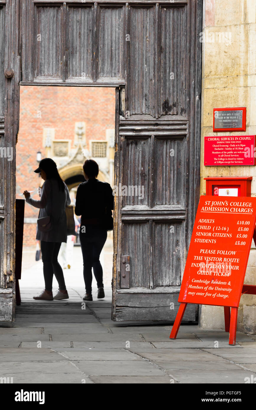 Due visitatori stagliano nella porta all'ingresso principale di St John's College, Università di Cambridge, Inghilterra. Foto Stock
