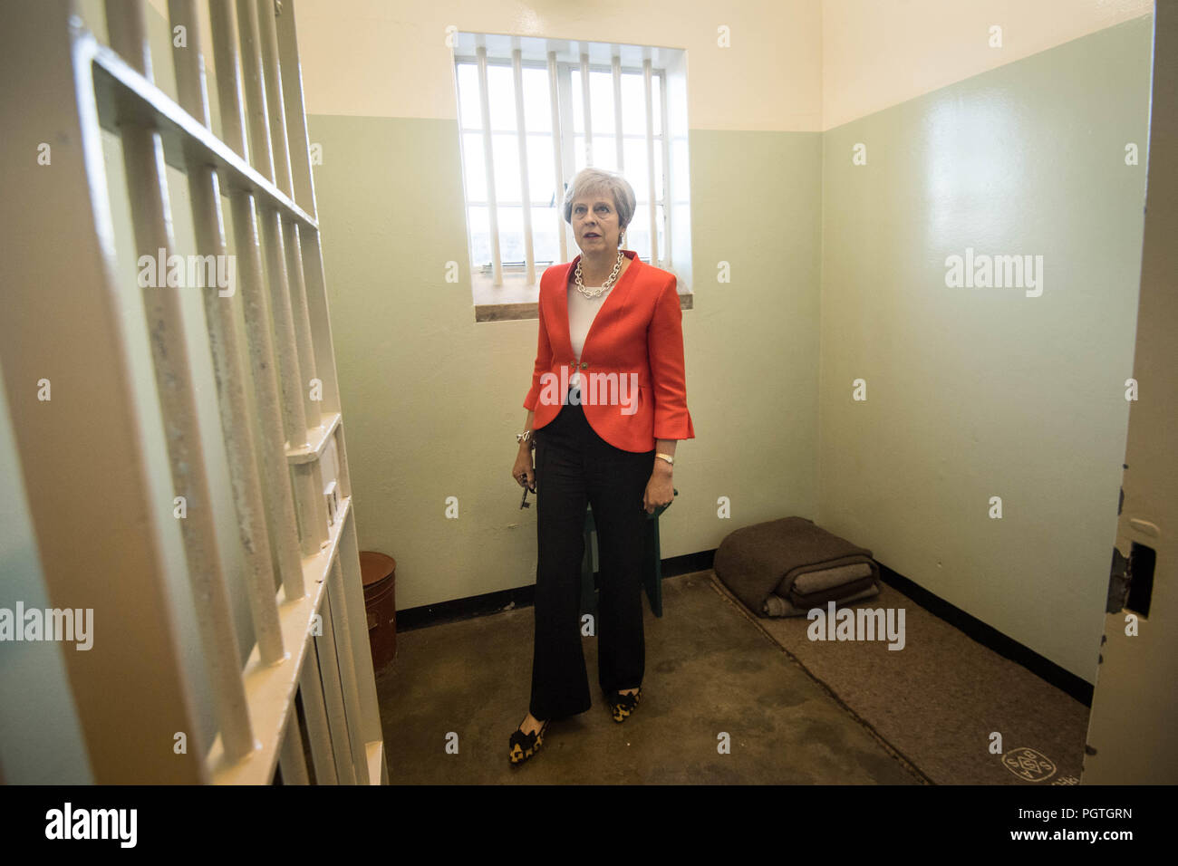 Il primo ministro Theresa Maggio entra in una cella di Robben Island Cape Town, Sud Africa, che ospitava il prigioniero politico Nelson Mandela, che è andato a diventare Presidente del Sud Africa e che è stata mantenuta per 18 anni. Foto Stock