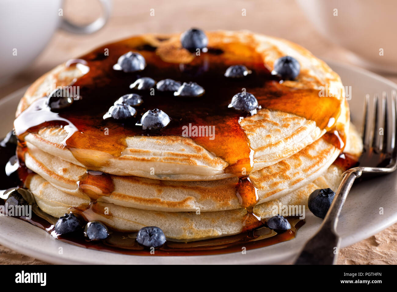 Una piastra di deliziose frittelle di mirtilli con sciroppo d'acero puro. Foto Stock