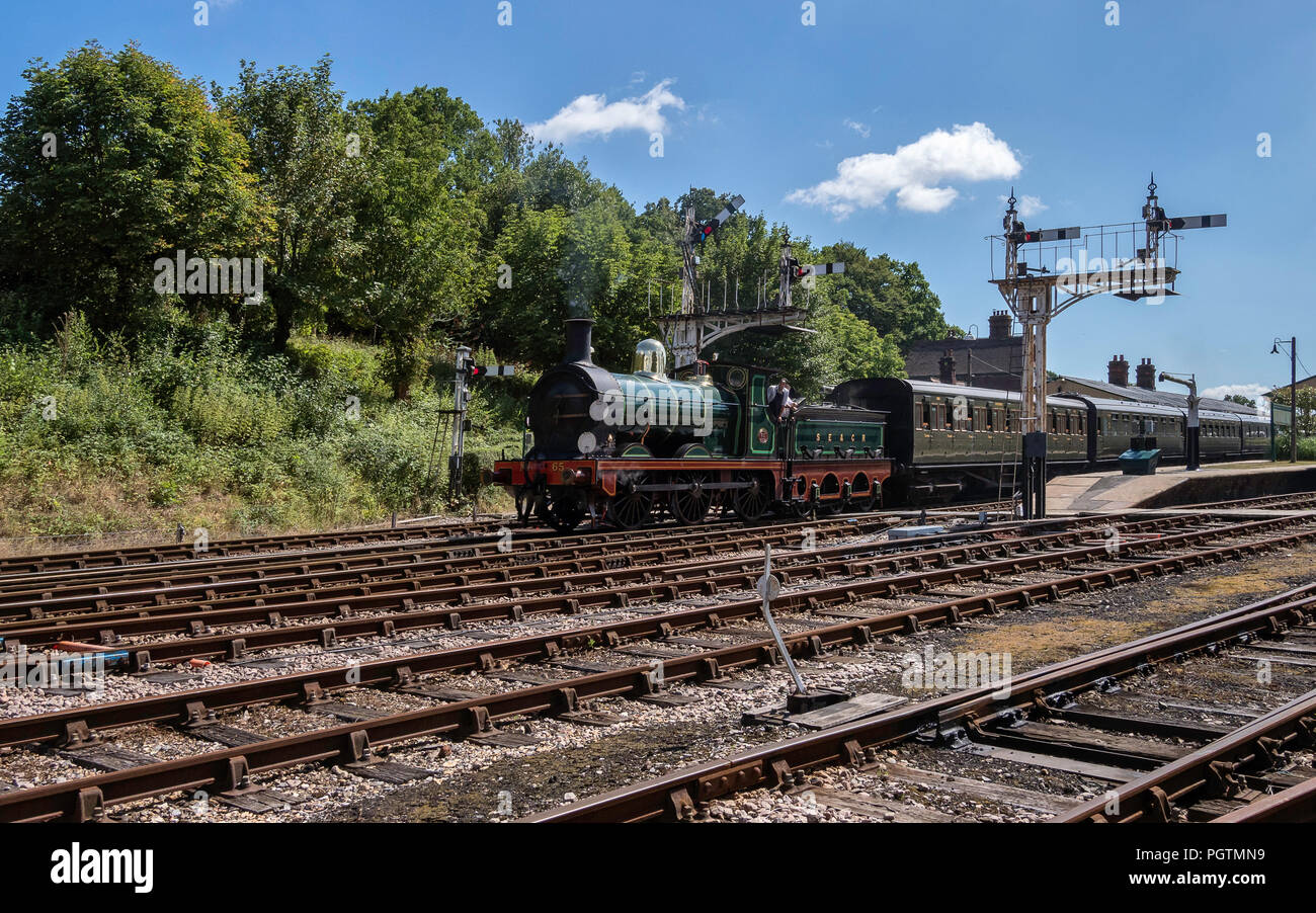 Treno a vapore e carrelli lasciando Horsted Keynes stazione, East Sussex, Inghilterra Foto Stock