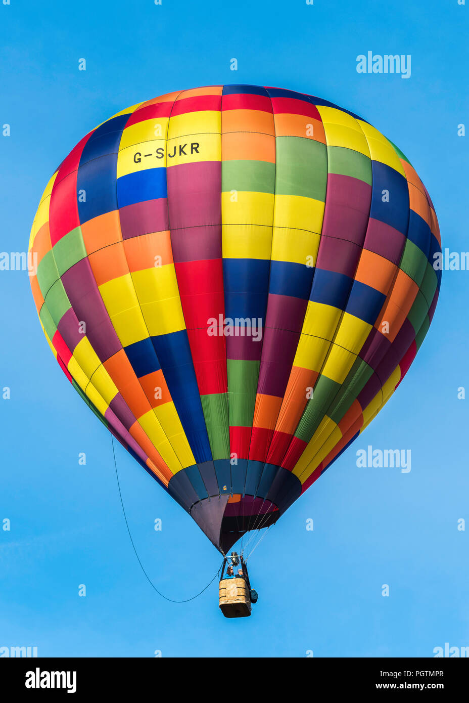 Multi-colore di palloncino in un cielo azzurro oltre il Bristol Balloon Fiesta, Inghilterra Foto Stock