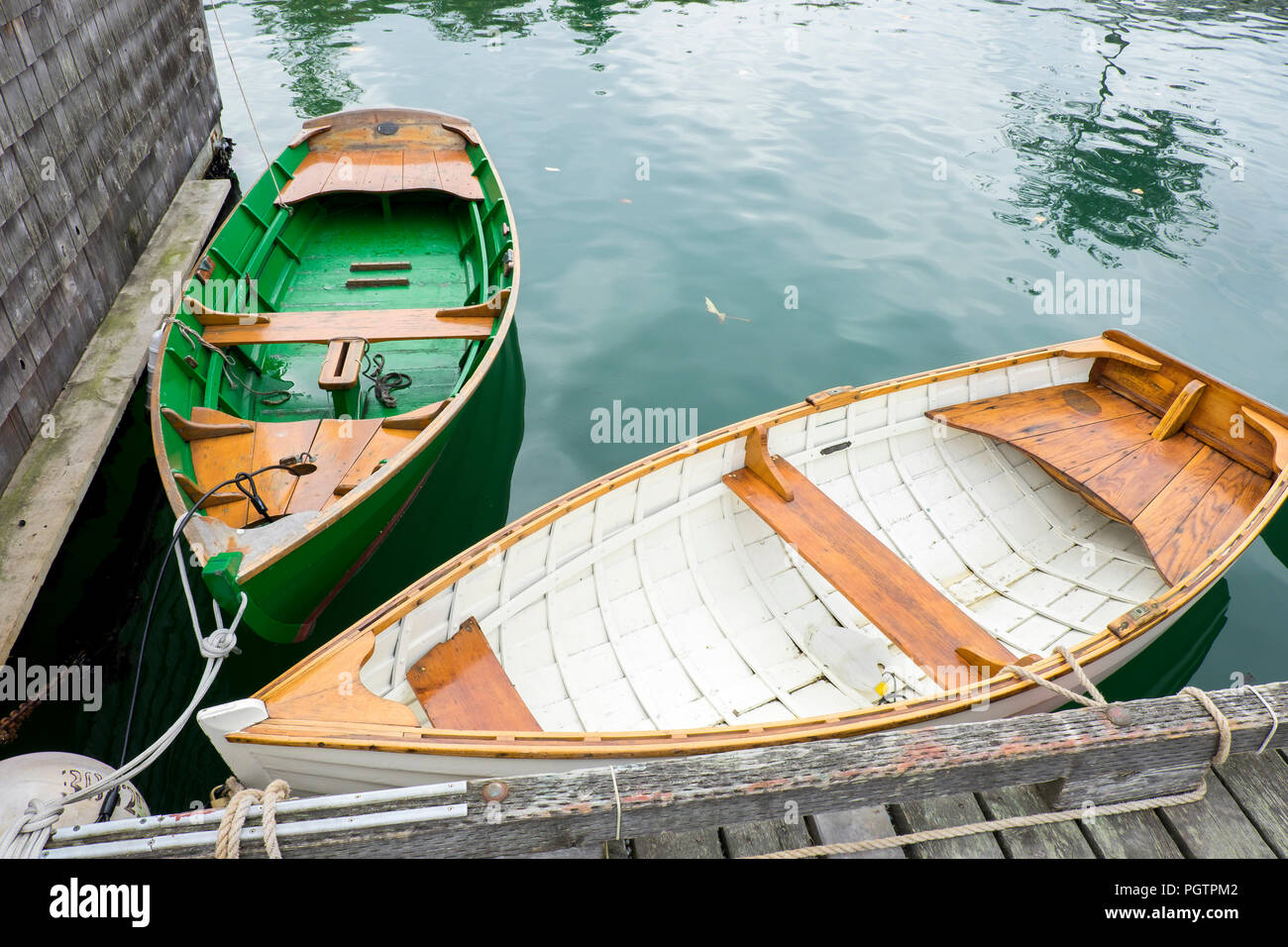 Un verde e bianco vintage riga di legno in barca nelle acque ancora in Vancouver B.C. Foto Stock