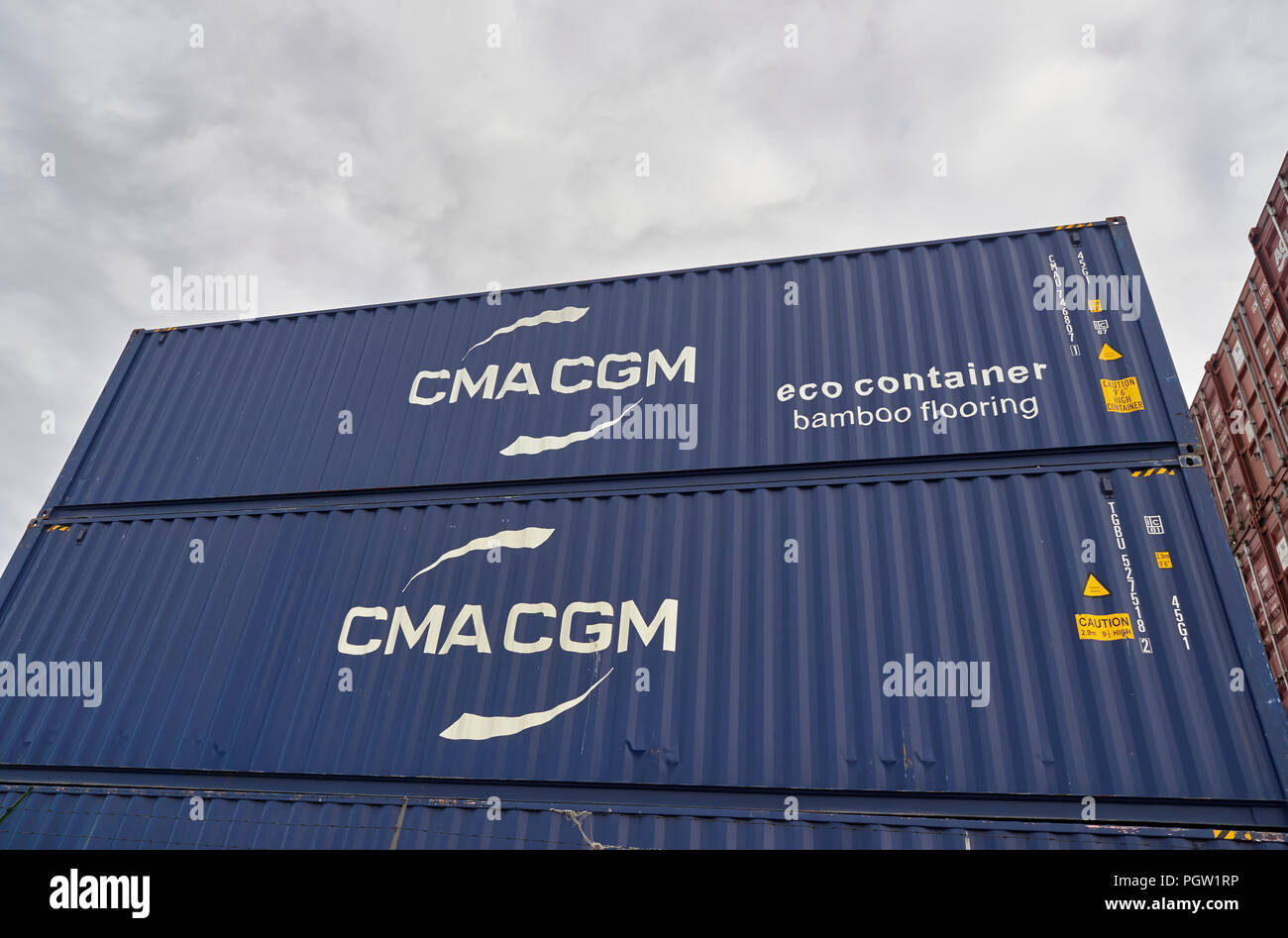 In prossimità di alcuni Blue CMA CGM spedizione Eco contenitori impilati fino a Den Haag (L'Aia) pronto per la spedizione da qualche parte. I Paesi Bassi. Foto Stock