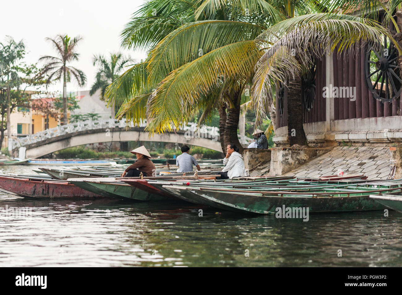 Ottobre 17, 2016 - Van Lam Village, Vietnam. Donne locali del riso cappelli a guardare oltre le barche a Vung Tram Pier. Pala tradizionale-barche lungo th Foto Stock