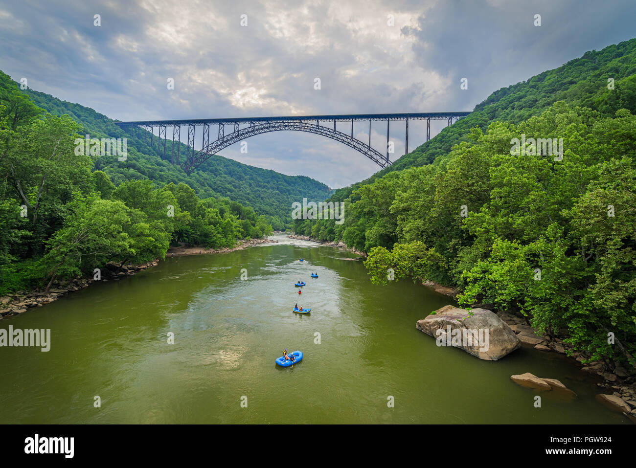 Acqua bianco rafters flottazione verso il basso il nuovo River Gorge in West Virginia sotto il grande arco in acciaio ponte. Foto Stock