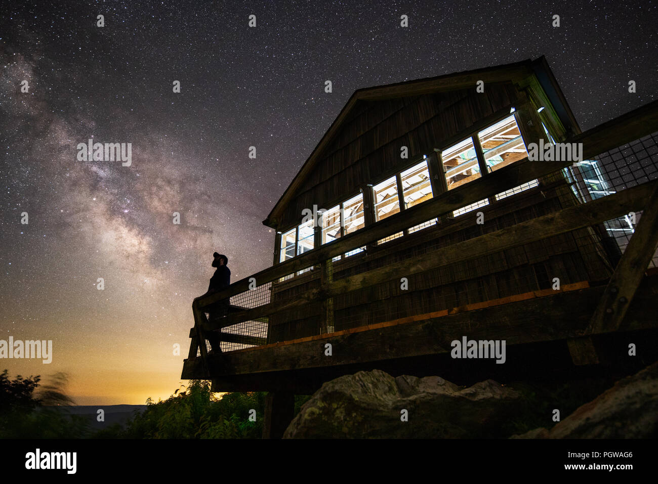 Un Lone Star gazer si stagliano contro la Via Lattea e un cielo notturno dal Ponte della vecchia torre antincendio all'Hanging Rock Raptor Observatory Foto Stock