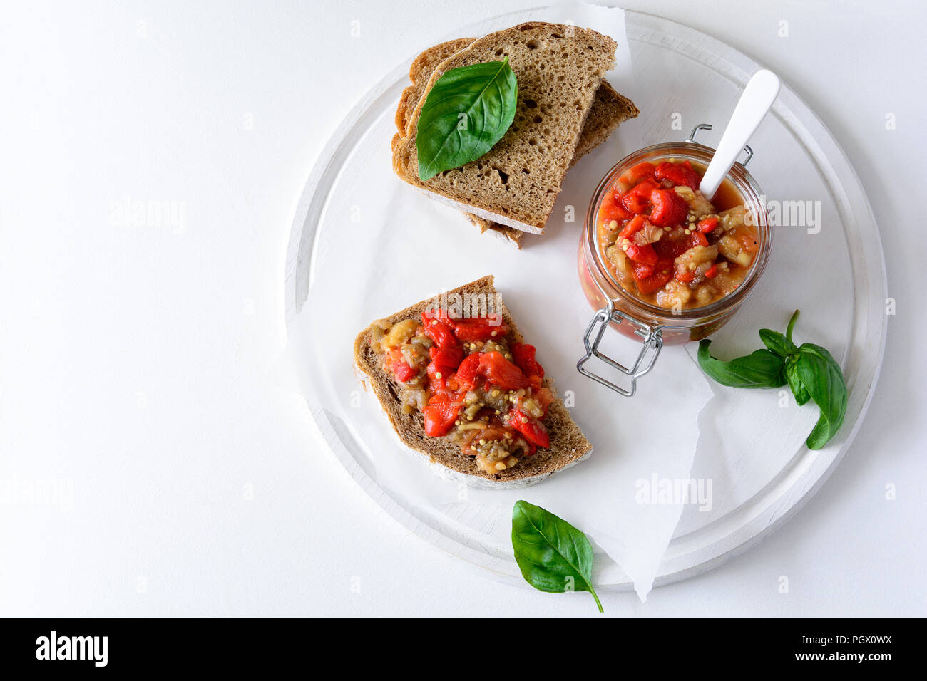 Pane di segale toast e vaso di vetro con caviale di melanzana. Antipasto di verdure antipasti o. Cibo sano concetto Foto Stock