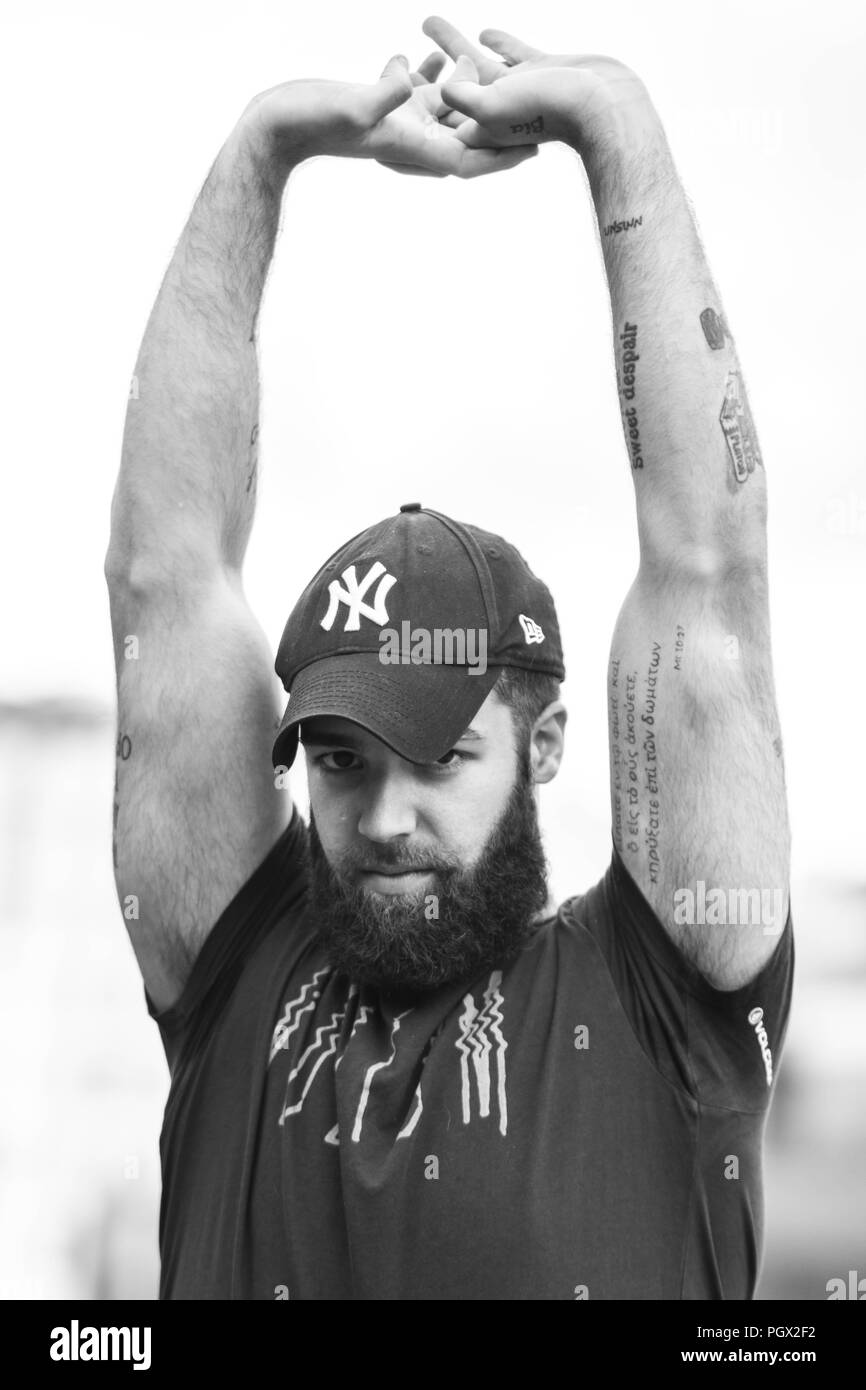 Ritratto di un giovane hipster tatuato uomo con New York Yankees hat Foto Stock