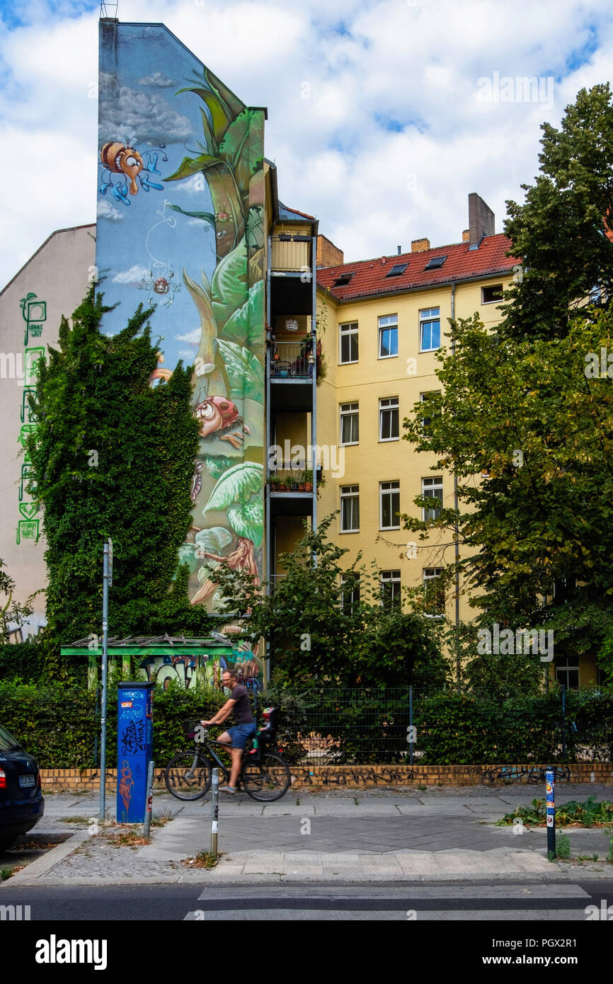 Berlin Friedrichshain, appartamento edificio con vernice colorata sul firewall. La pittura di fiori, insetti, coccinella & Bees. Foto Stock