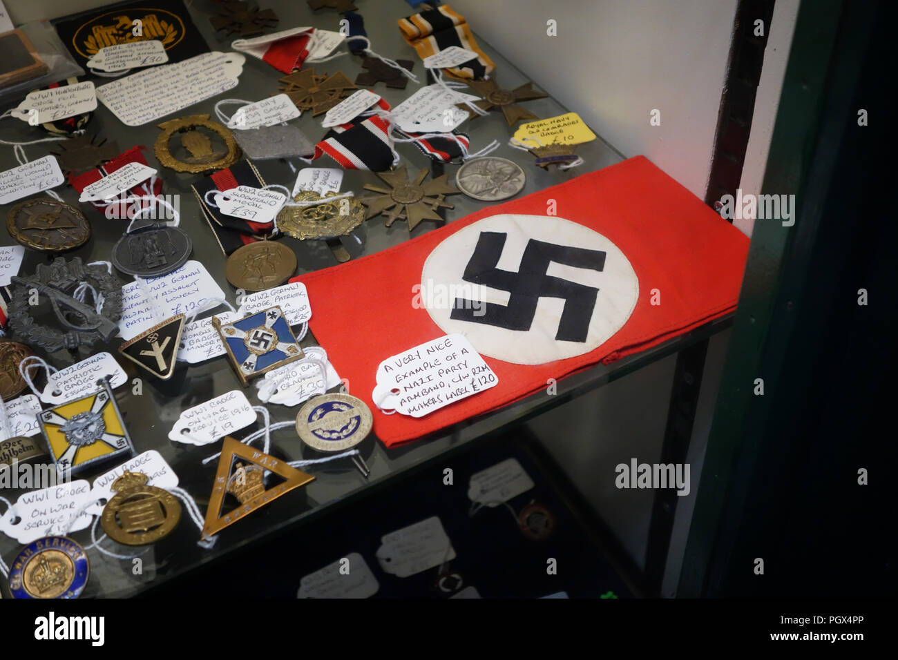 Tedesco partito nazista Swastika armband e medaglie militari e di voci di bric-à-brac sul display un inglese un centro di antiquariato Foto Stock